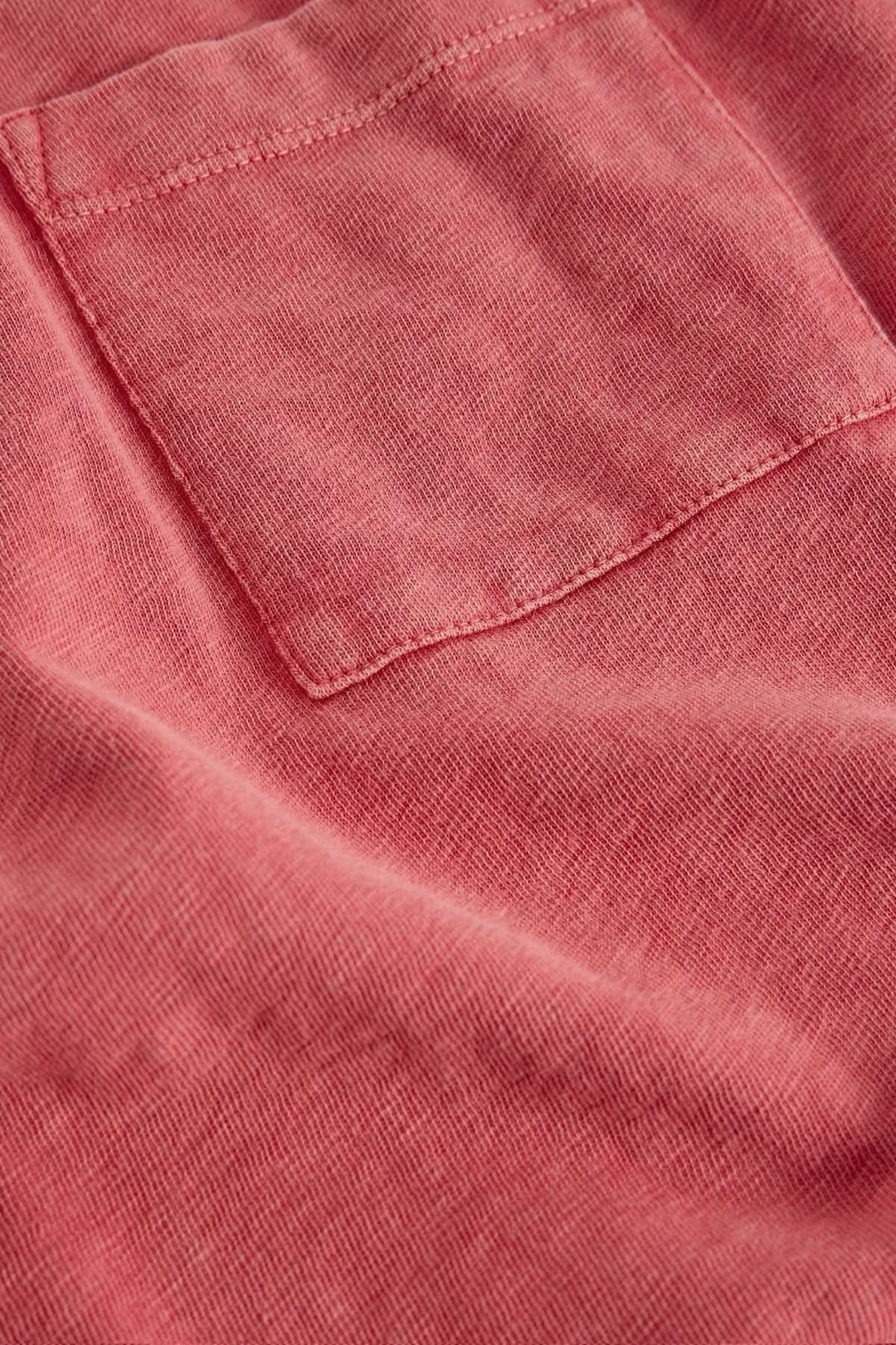T-shirt à col rond demi-dos avec poche plaquée et tissu doux en gros plan.