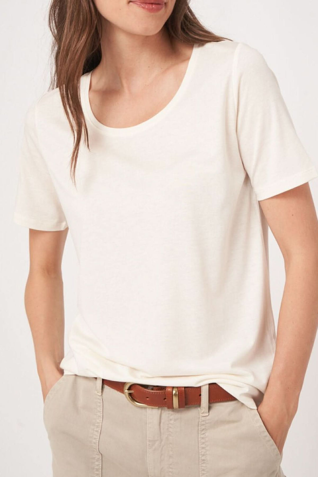 T-shirt col rond manches courtes blanc porté avec pantalon beige, design minimaliste et confortable.