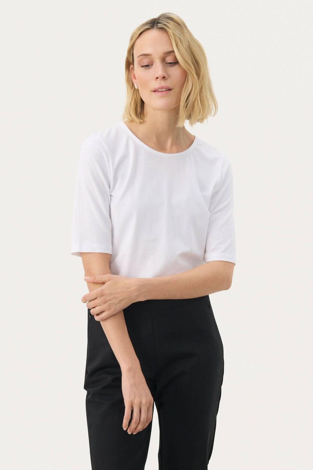 Femme portant un t-shirt coupe droite Nemi blanc minimaliste, idéal pour un look moderne et polyvalent.