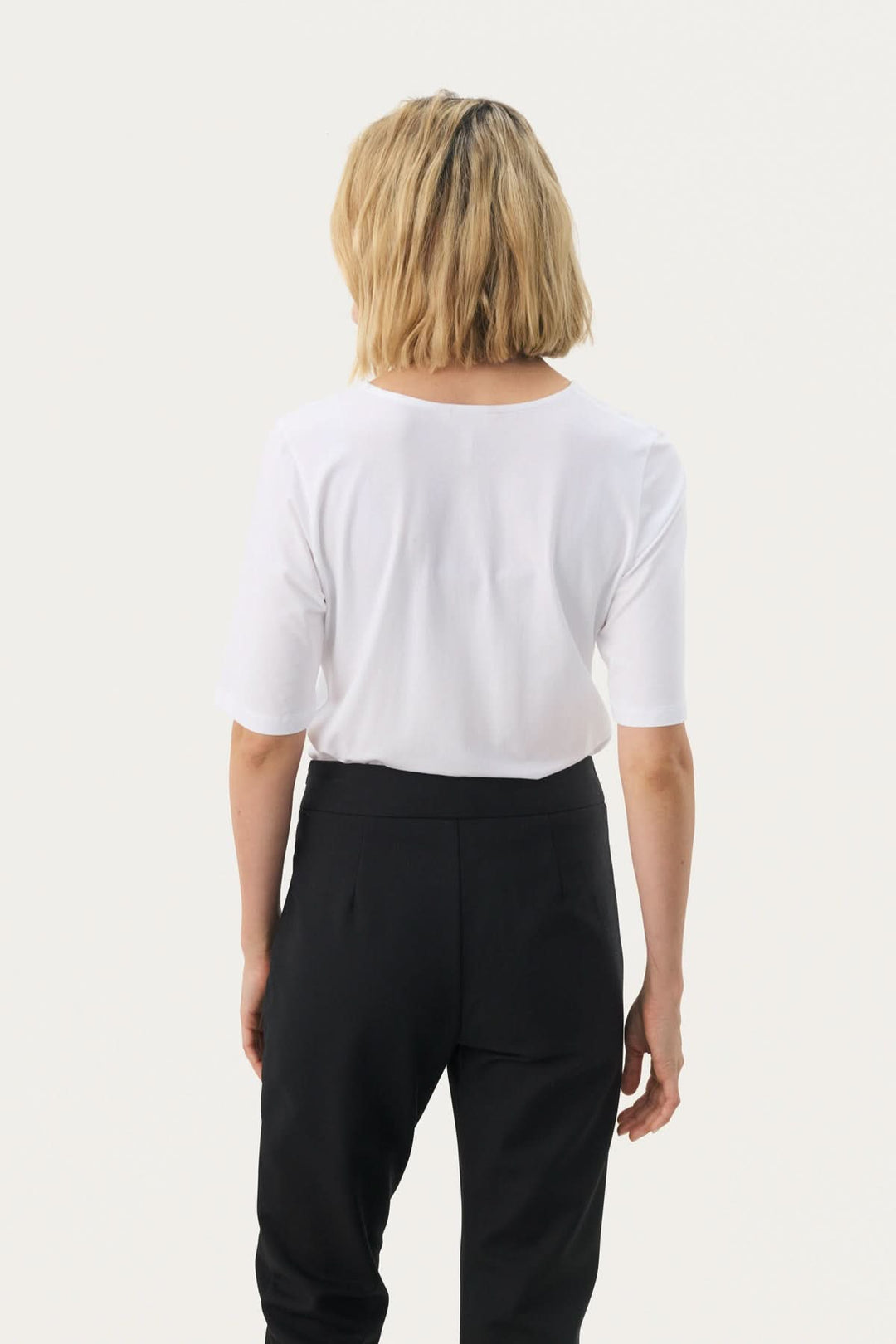 Femme portant un T-shirt coupe droite Nemi, vue arrière, style minimaliste et moderne, parfait pour une garde-robe polyvalente.