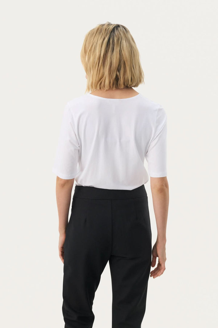 Femme portant un T-shirt coupe droite Nemi, vue arrière, style minimaliste et moderne, parfait pour une garde-robe polyvalente.