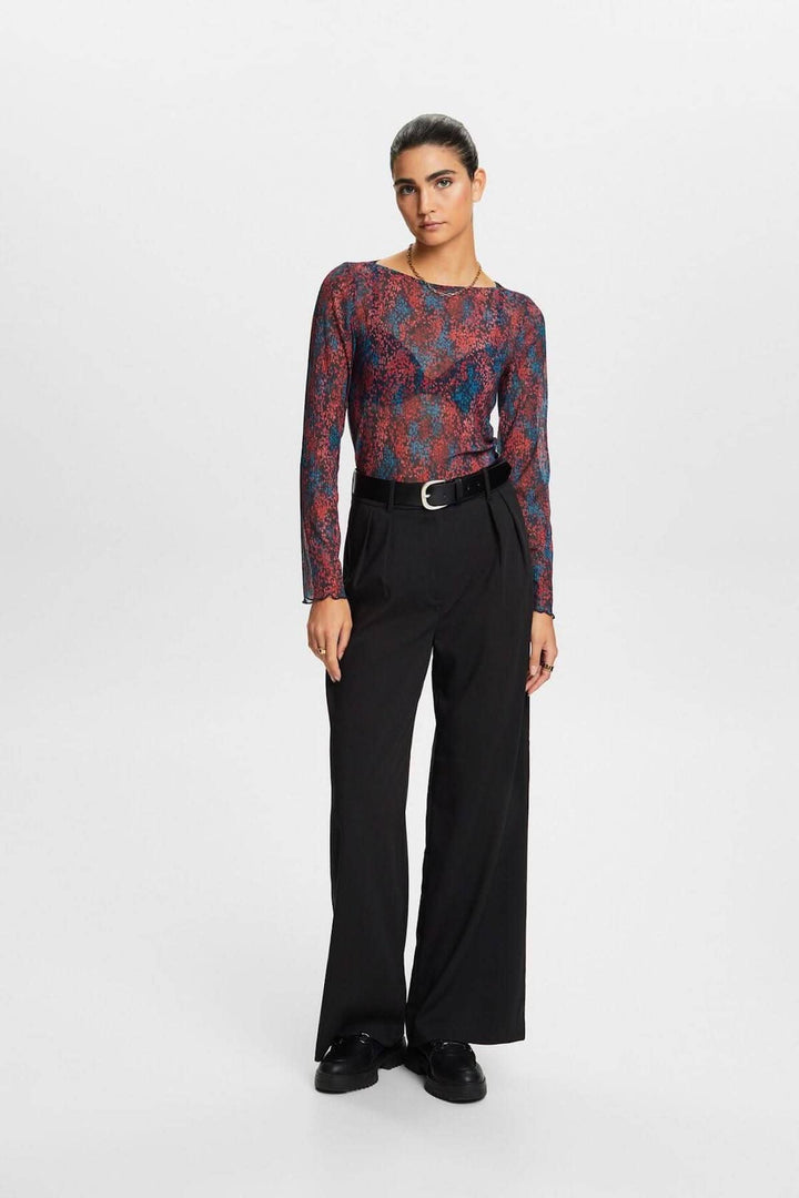 T-shirt en mesh plissé à motif floral, porté avec un pantalon noir, pour un look féminin et élégant.