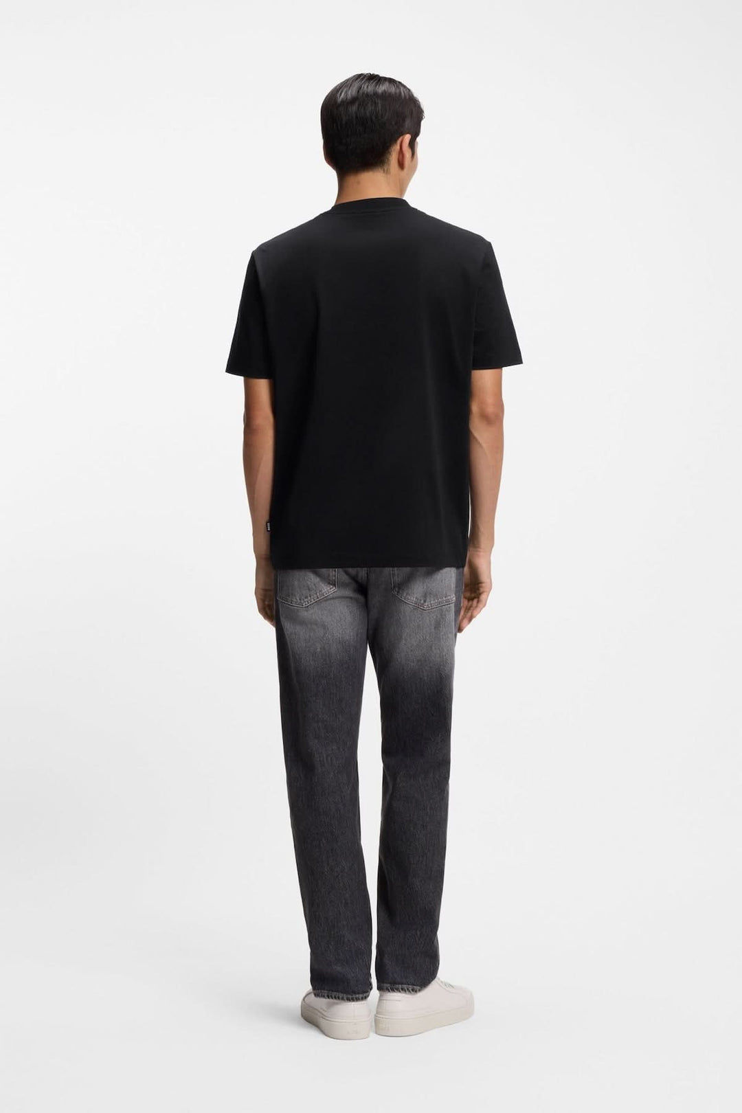 Homme portant un T-shirt à imprimé graphique minimaliste avec coupe droite et manches courtes, vu de dos.