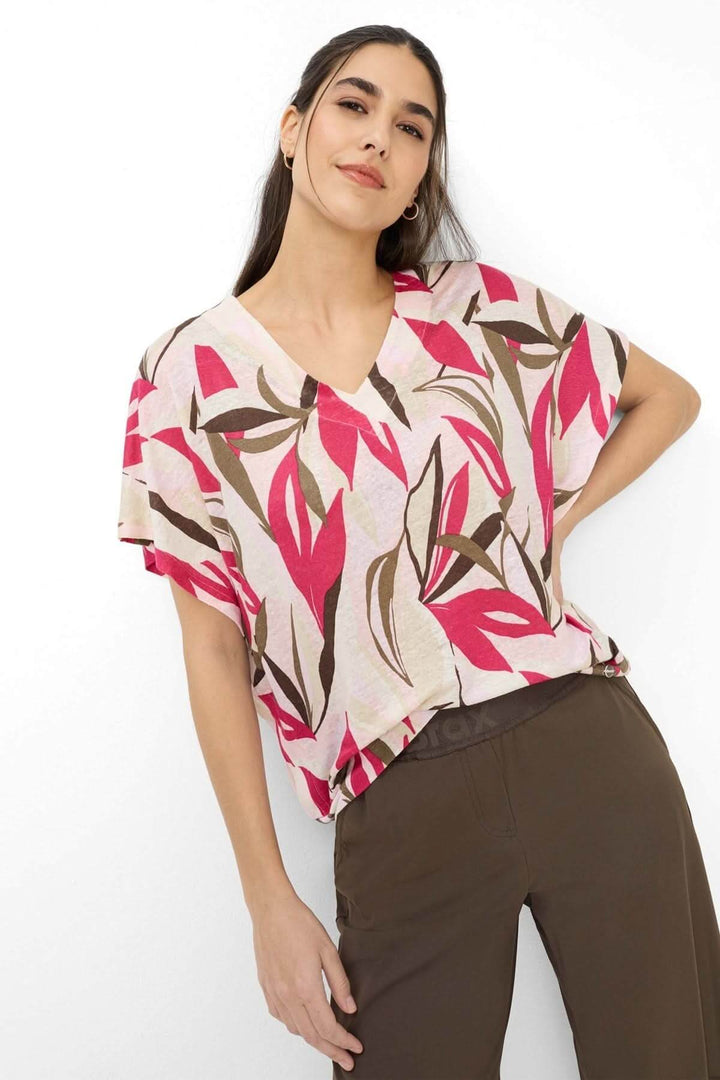 Femme portant un T-shirt imprimé végétal Cassie à encolure en V et coupe ample, idéal pour un style décontracté et élégant.