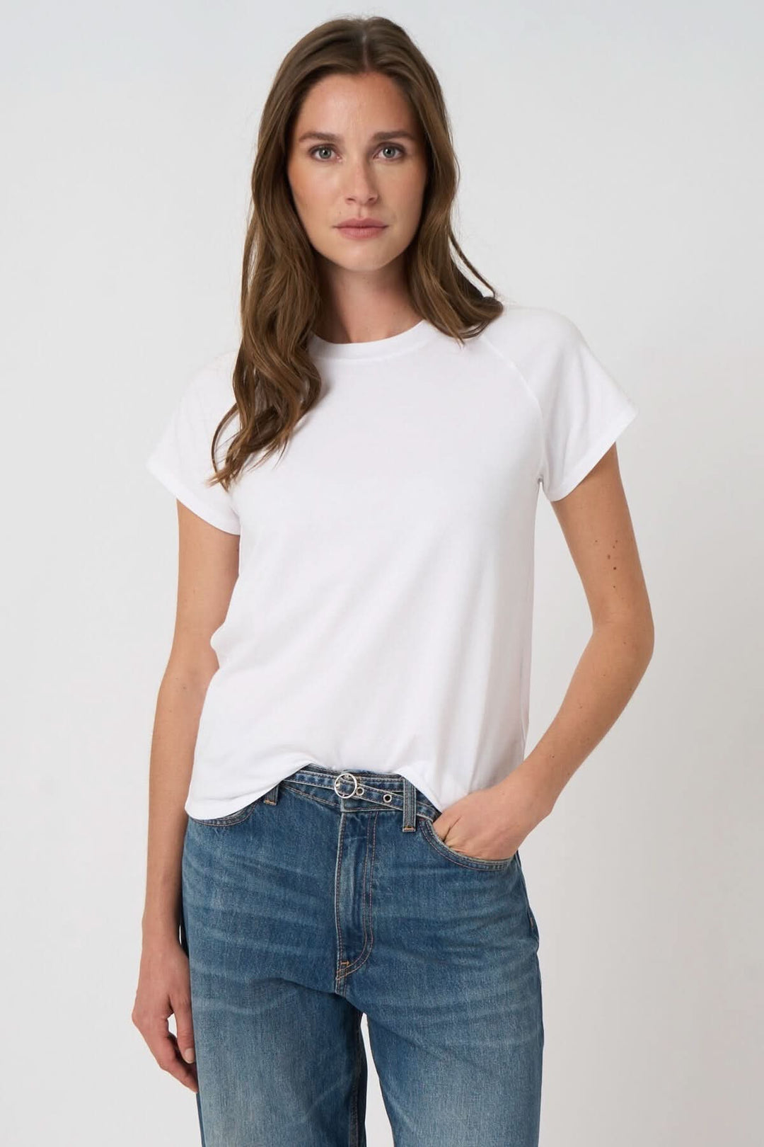 Femme portant un T-shirt à manches courtes blanc avec coupe droite et confortable en tissu doux, idéal pour un style quotidien polyvalent.