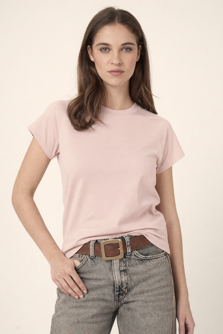 Femme portant un T-shirt à manches courtes rose avec une coupe confortable et tissu doux, idéal pour un style polyvalent et quotidien.