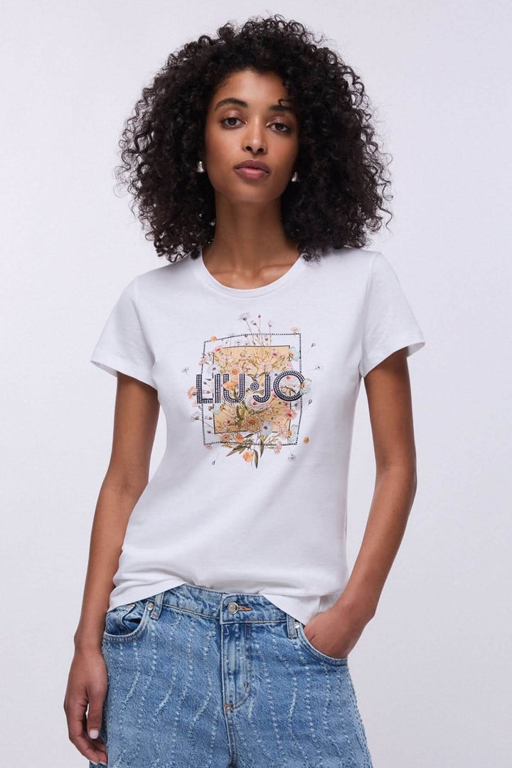 Femme portant un T-shirt à manches courtes avec imprimé graphique, coupe décontractée, encolure ronde, et jeans.