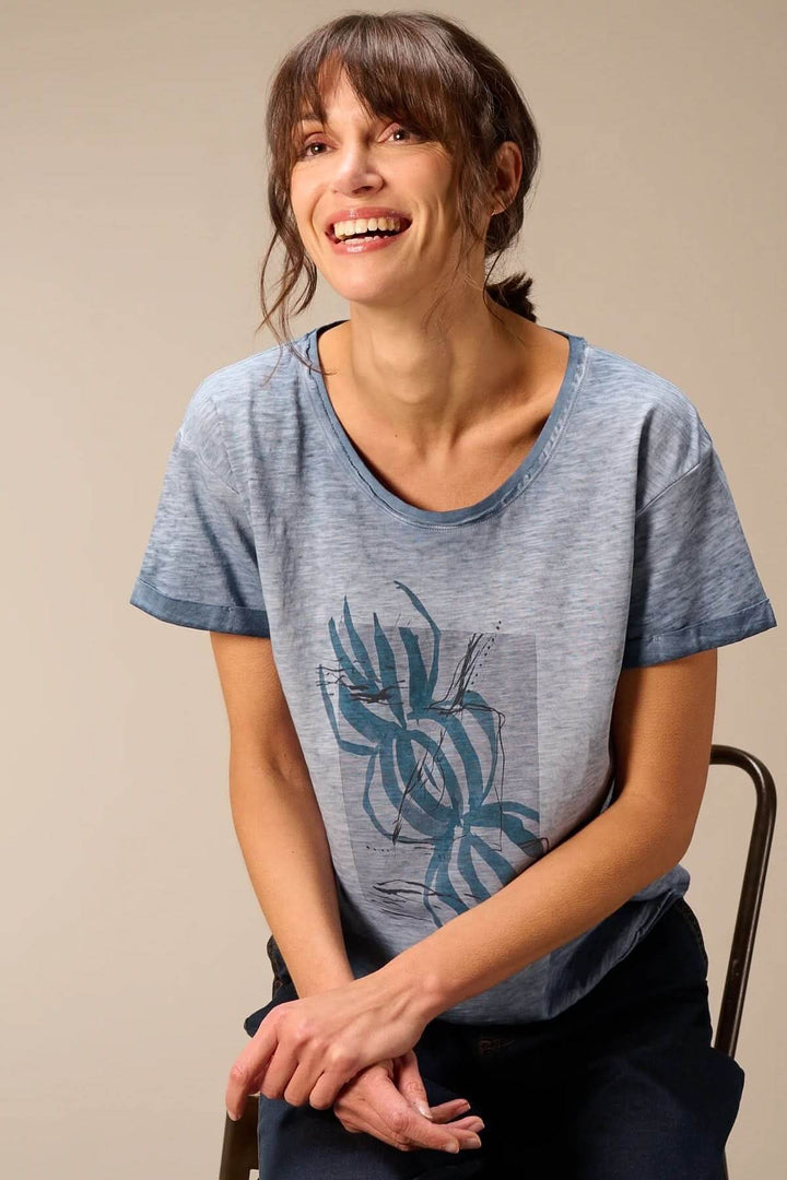 Femme portant un T-shirt à manches courtes coupe décontractée avec un imprimé graphique, idéal pour un look casual et confortable.