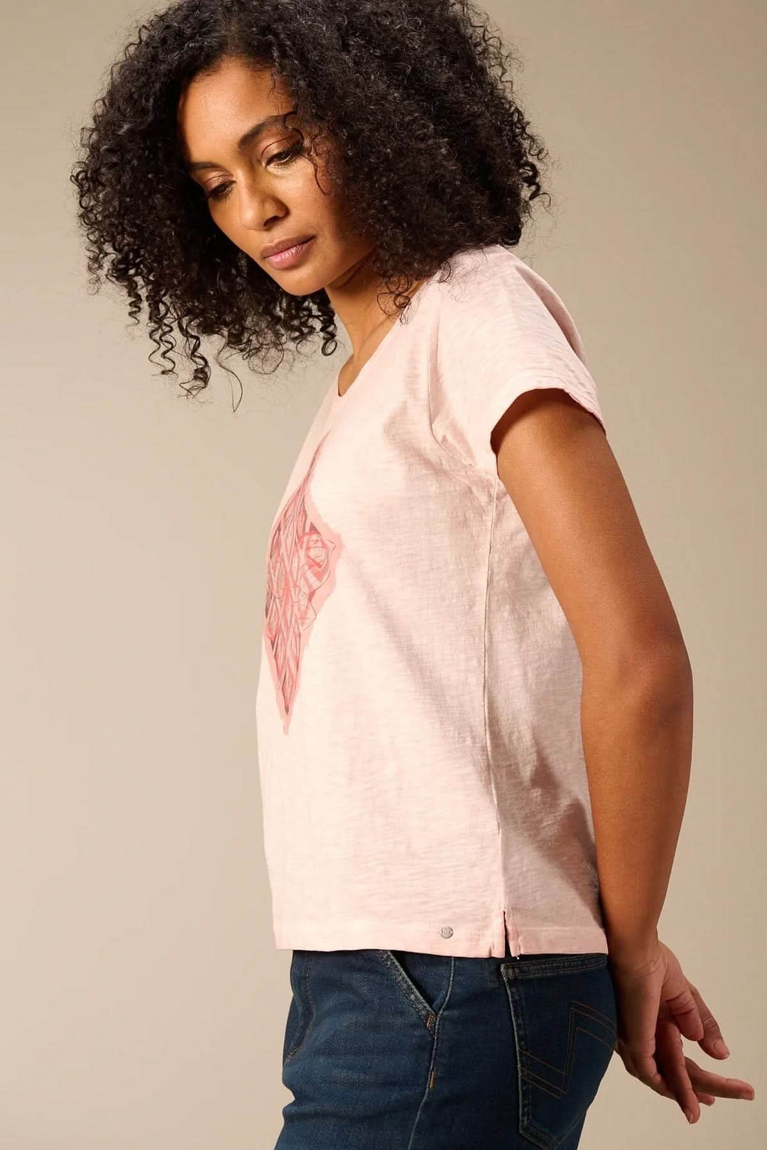 Femme portant un T-shirt à manches courtes coupe décontractée, silhouette fluide, tissu doux, couleur rose, style quotidien moderne