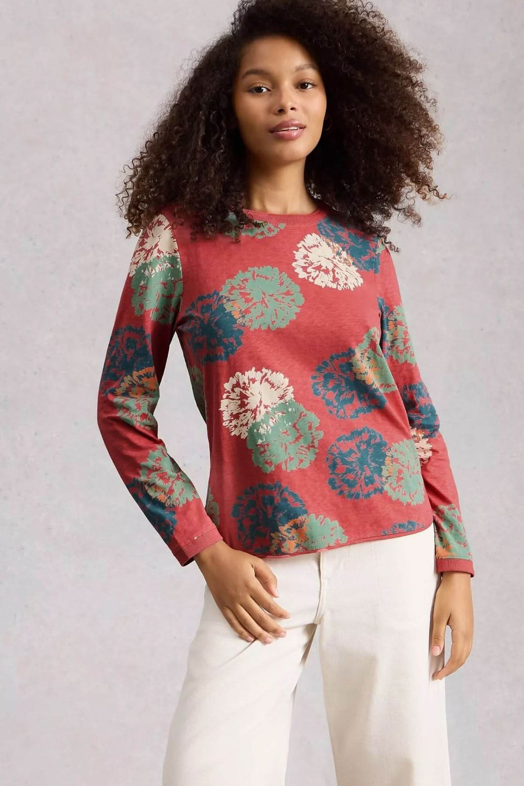 Femme portant le T-shirt à manches longues Clara avec motif floral, coupe droite, encolure ronde, tissu doux, idéal pour le quotidien.