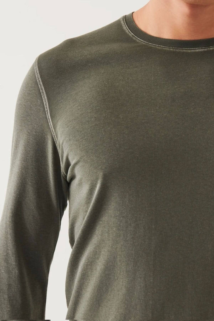 Haut en coton pima vert olive, à manches longues et col rond, coupe décontractée.