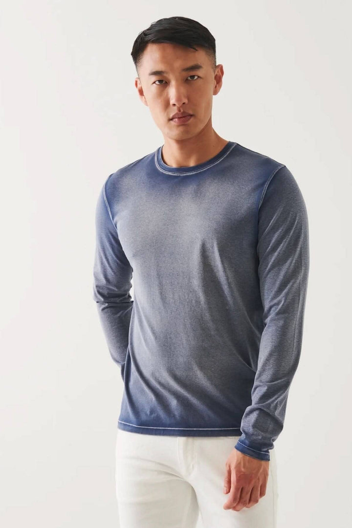Homme portant un t-shirt à manches longues en coton pima, couleur bleu, avec une coupe décontractée et col rond.
