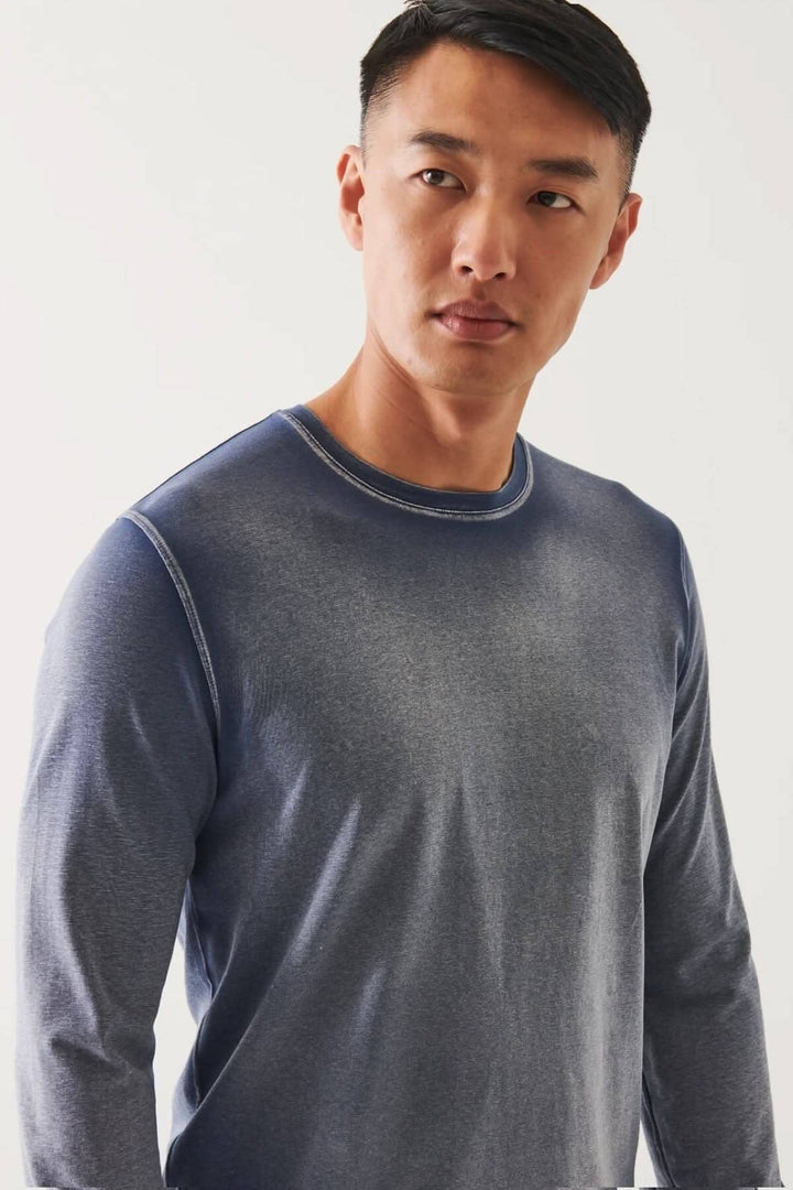 Homme portant un t-shirt à manches longues en coton pima, coupe décontractée, couleur bleu dégradé.