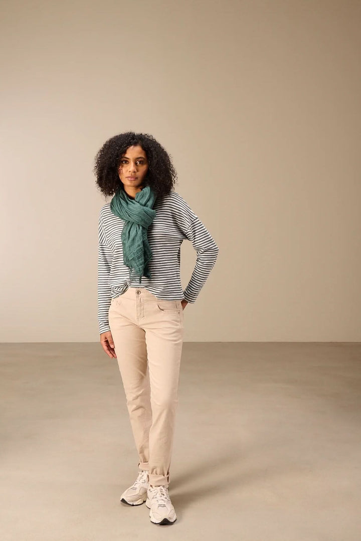 Femme portant un T-shirt à manches longues rayé col rond, avec motif rayé, coupe décontractée et confortable, mode moderne et casual.