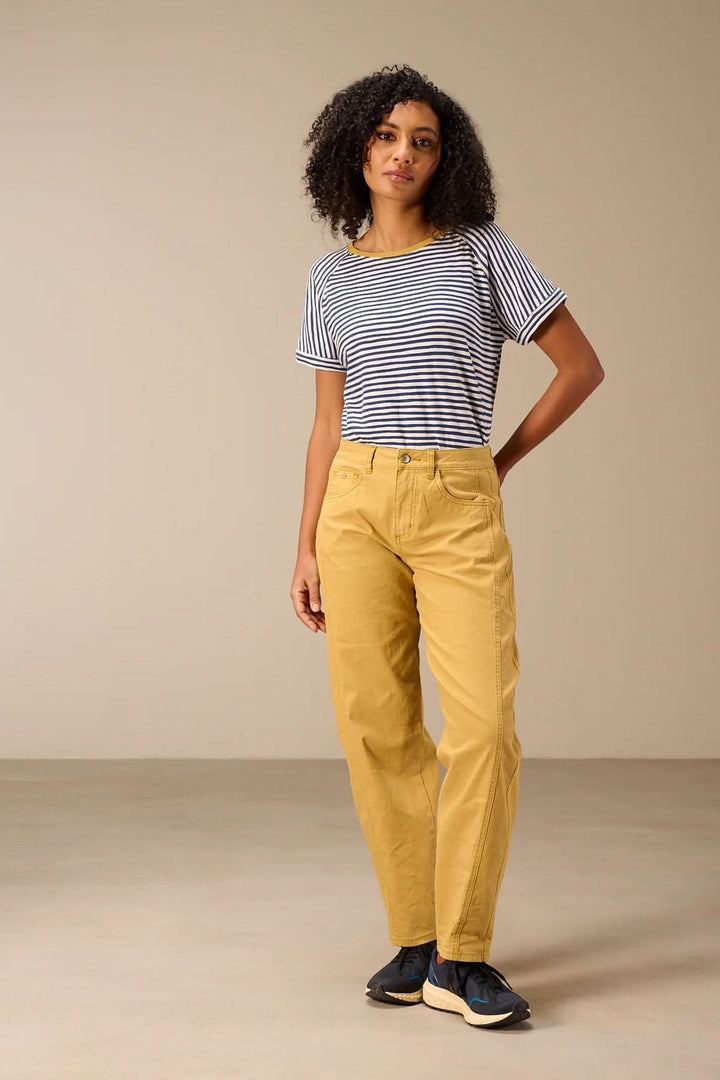 T-shirt rayé manches courtes style raglan porté avec pantalon jaune, femme debout, style décontracté et moderne.