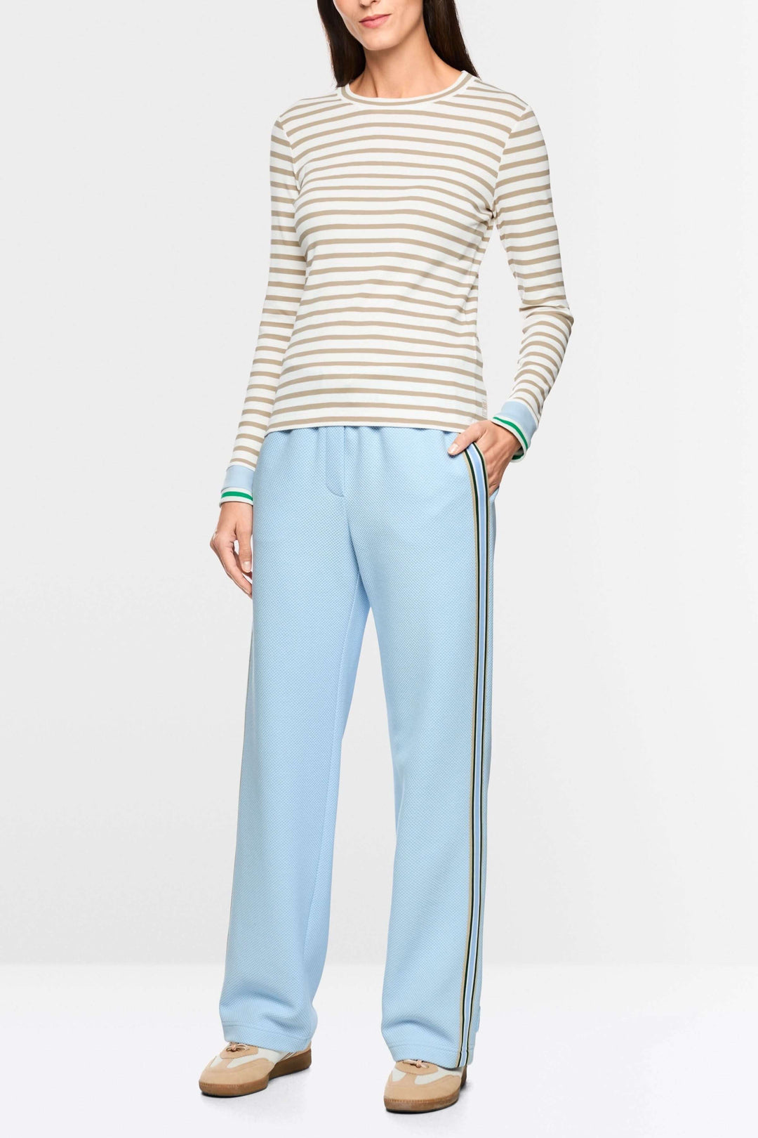 T-shirt rayée cintrée avec manches longues et encolure ronde, porté par un modèle. Mode contemporaine, polyvalente et ajustée.