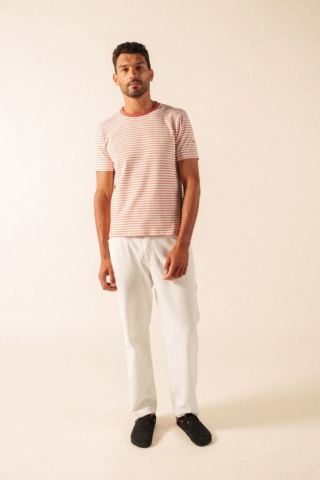 Homme portant un T-shirt à rayures fines avec coupe moderne et confortable, idéal pour un style décontracté, tissu doux et manches courtes.