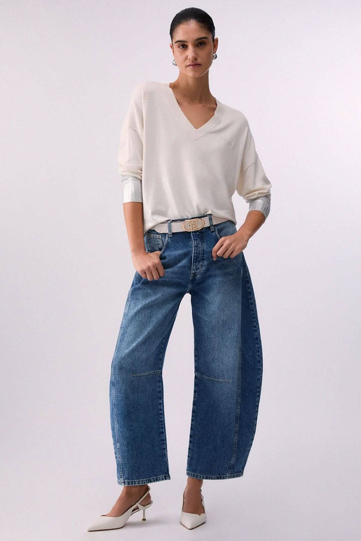 Femme portant un tricot col en V à manches trois-quarts avec poignets contrastants, style décontracté élégant.