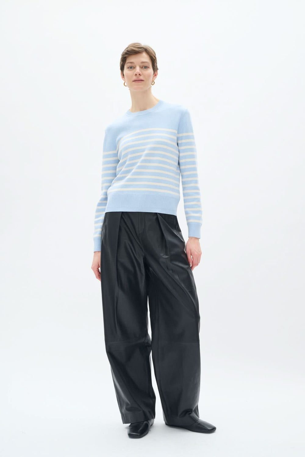 Tricot de coton rayé Wallis, col rond, style décontracté, porté avec un pantalon en cuir noir.