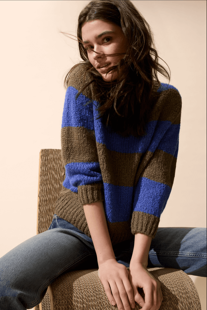Femme portant un Tricot rayures larges en laine et mohair bleu et marron avec manches 3/4, col ras du cou, assise sur une chaise.