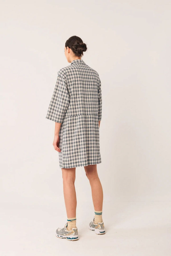 Tunique Vichy à carreaux, coupe droite, col chemise, manches trois-quarts, look décontracté, portée avec des baskets.