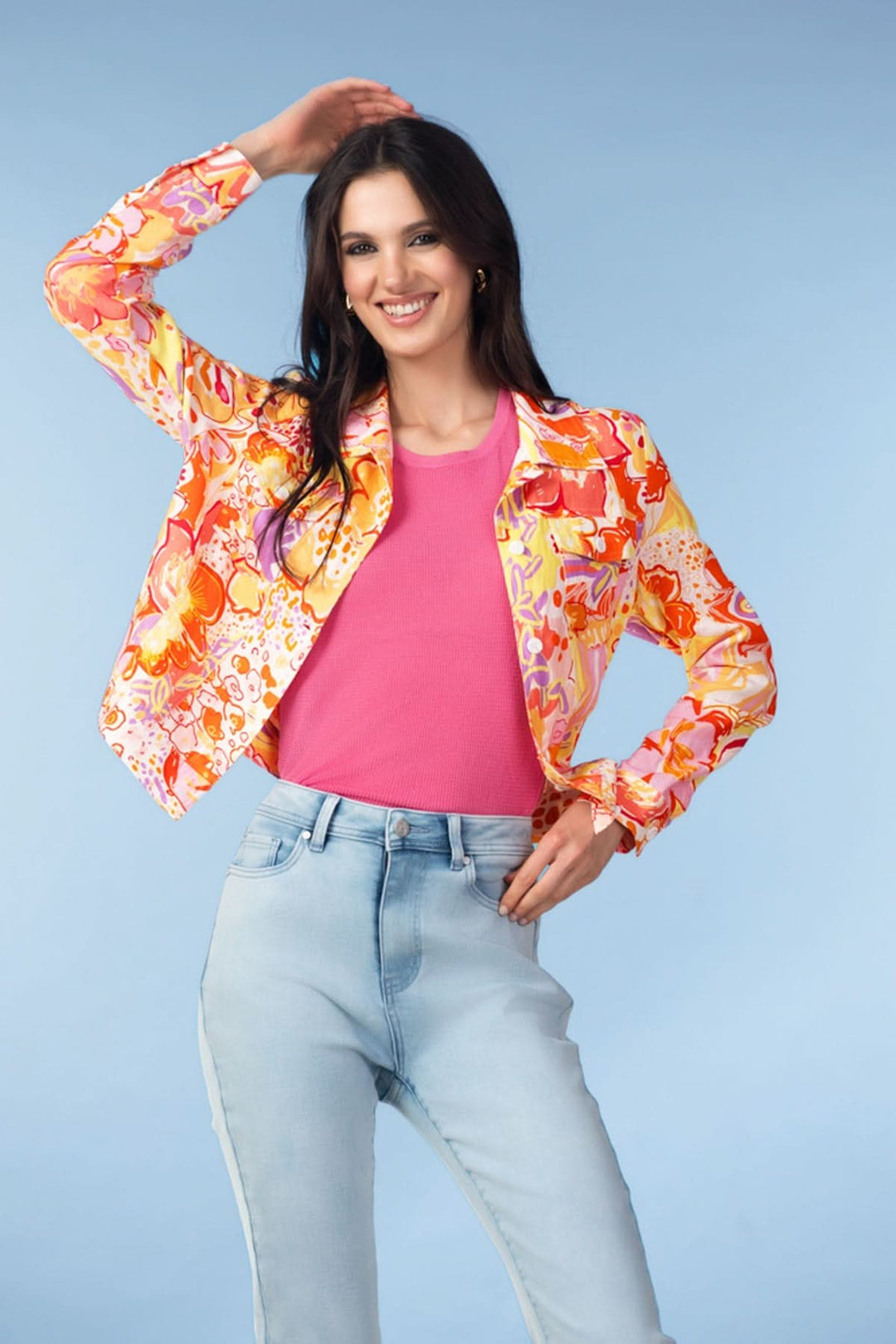 Veste avec manches à imprimé artistique, portée avec un t-shirt rose, créant un style moderne et élégant.