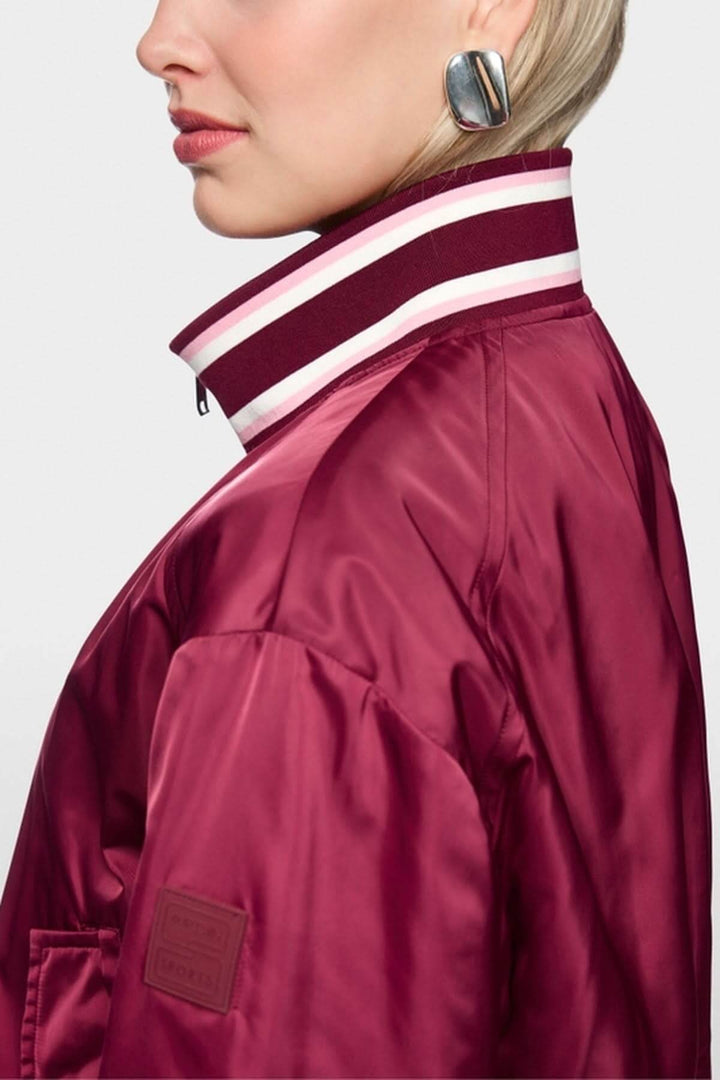 Close-up of a model wearing a Veste bomber réversible with contrasting knitted cuffs.