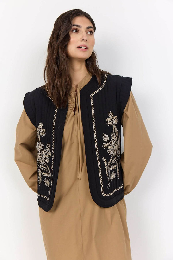 Veste courte sans manches noire avec broderies florales, modèle matelassé et encolure ronde pour un style décontracté.