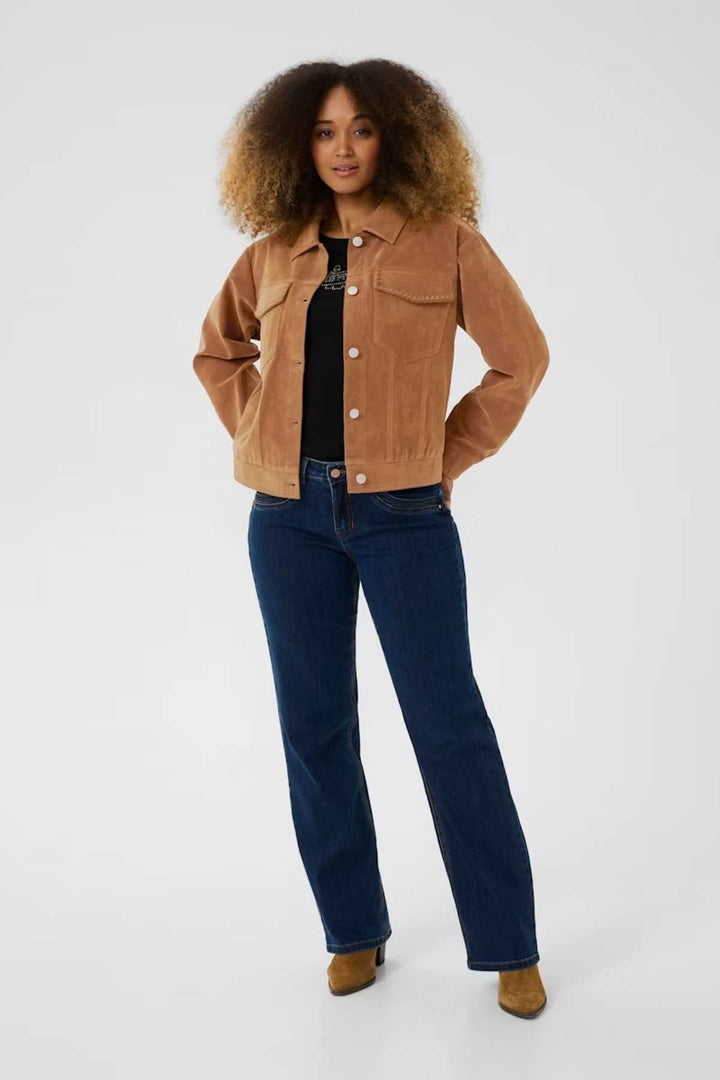 Femme portant une veste de style western en suédine avec détails soignés et jean foncé, look casual chic.