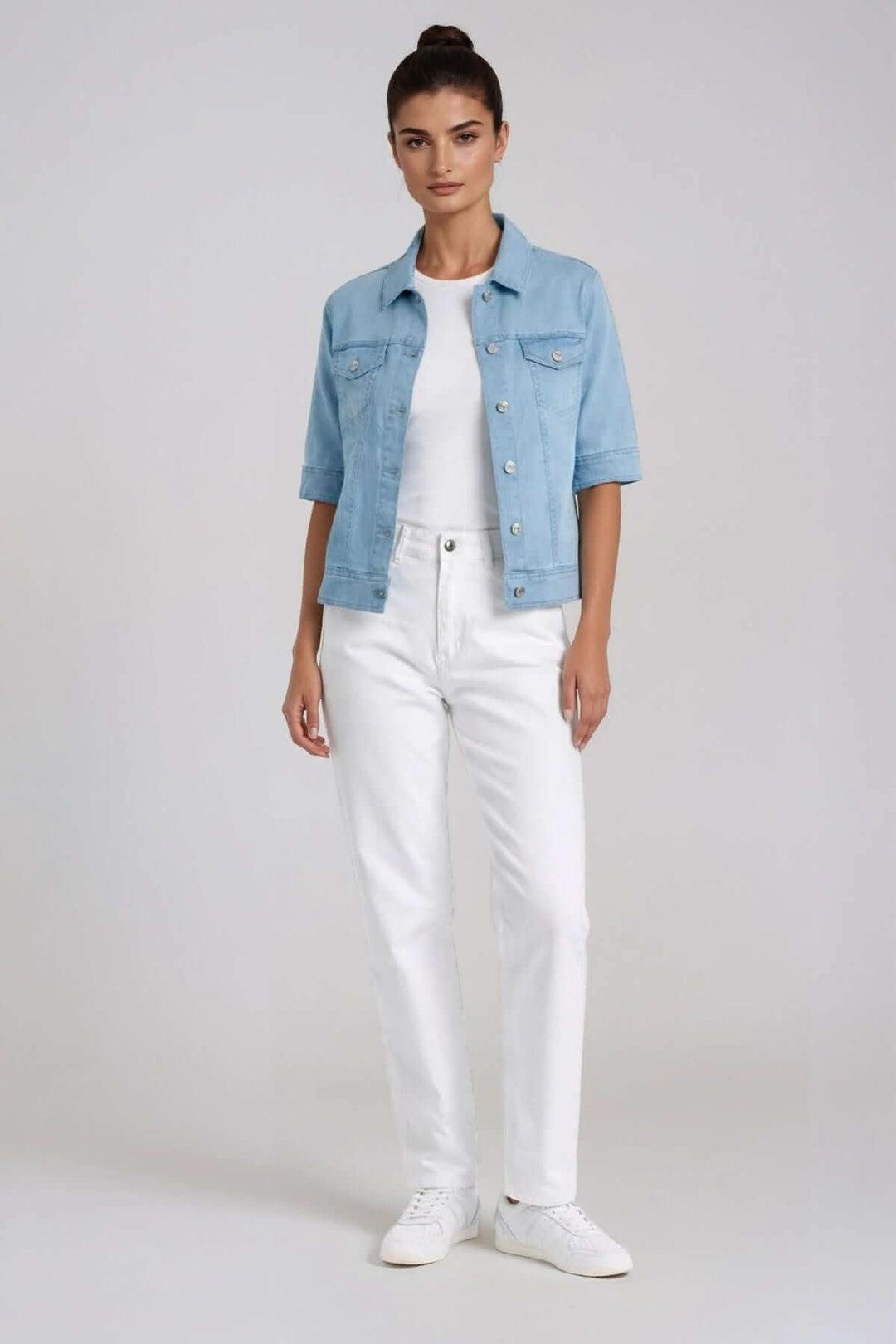 Femme portant une veste en denim manches courtes avec une coupe moderne et des détails structurés, parfait pour un look estival décontracté.