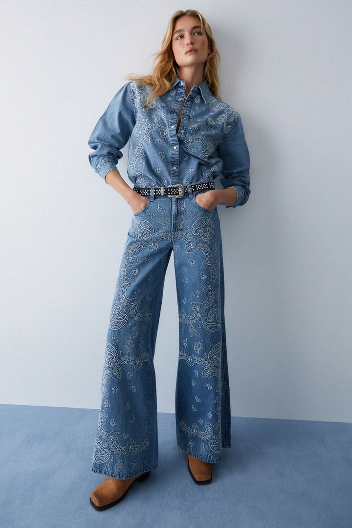 Veste en jean imprimée à boutons pression avec motif décoratif et coupe droite, confectionnée en denim souple pour un style moderne.