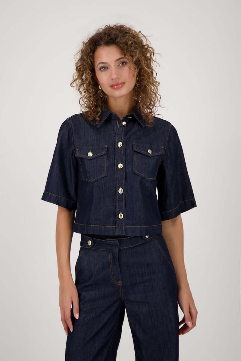 Veste en jean courte avec manches évasées et fermeture boutonnée, style casual-chic.