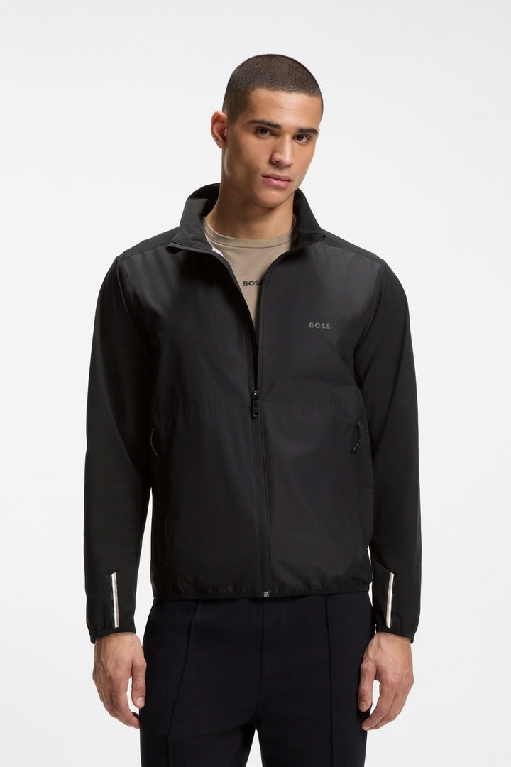 Homme portant une veste légère zippée à col montant noire élégante avec fermeture éclair sur le devant.