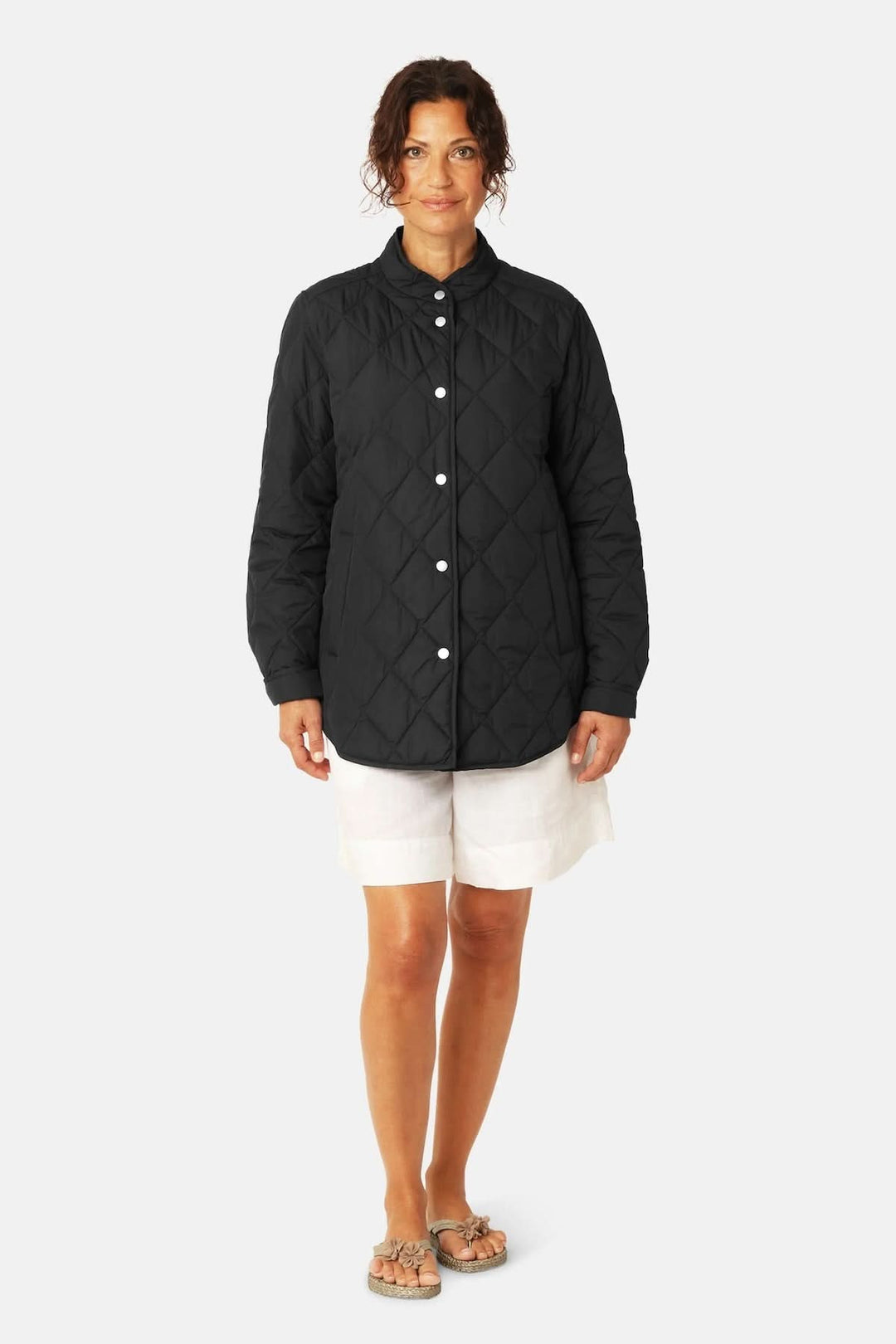 Veste matelassée légère à col montant en noir avec piquage losanges, femme debout, mi-saison, élégante et fonctionnelle