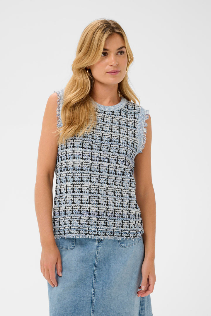 Veste sans manches Over en maille texturée avec motif structuré, finitions effilochées, portée avec un look moderne et raffiné.