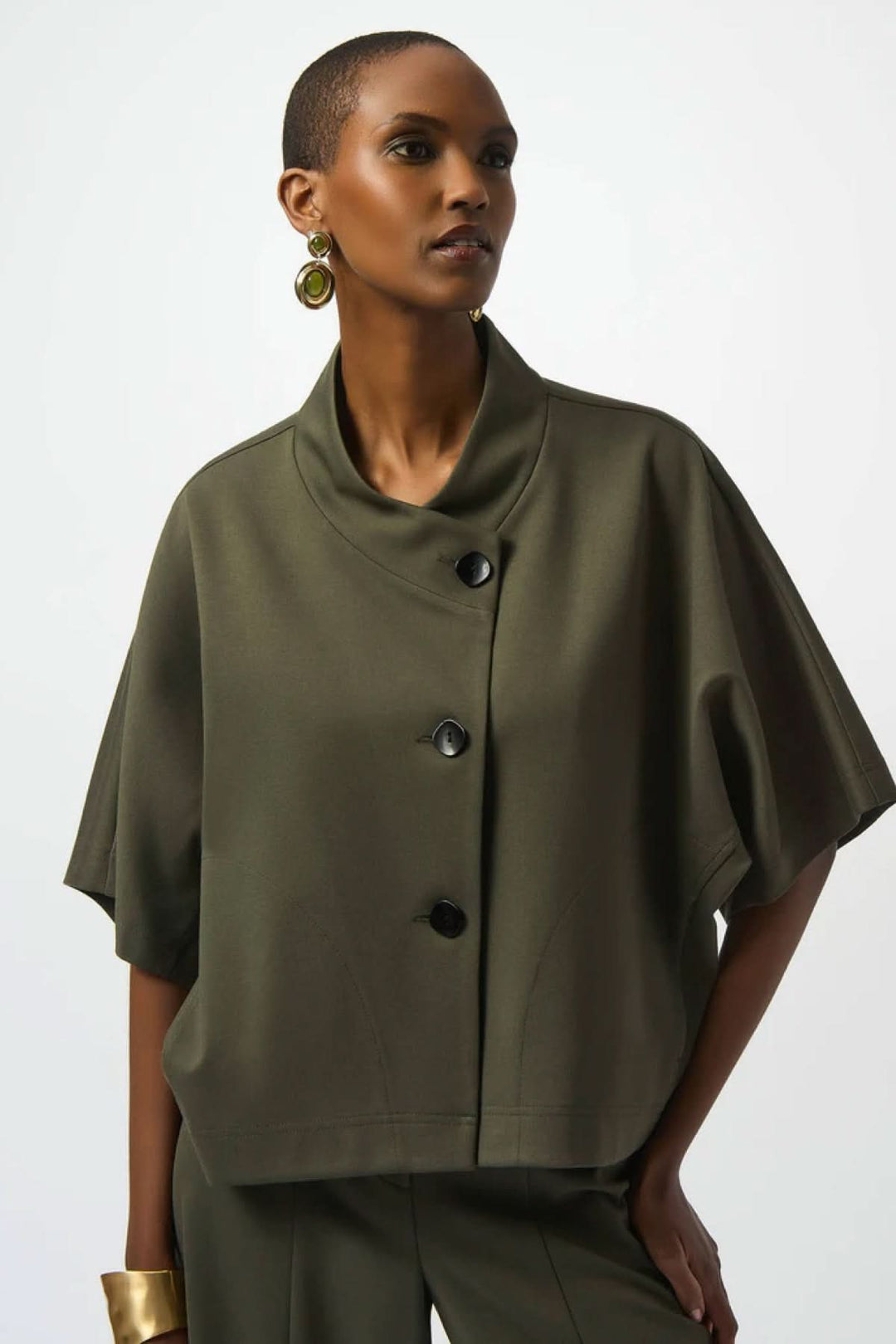 Veste style cape en vert olive, col drapé, boutons noirs, coupe ample et moderne, parfaite pour un look contemporain.