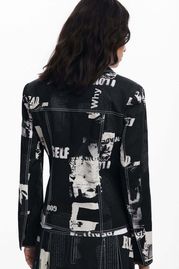 Femme portant une veste style motard à imprimé typographique contemporain, vue de dos, coupe structurée pour une allure audacieuse.
