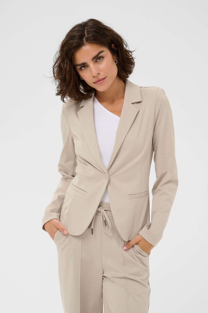 Femme portant le Veston Jenny beige avec coupe ajustée et col tailleur