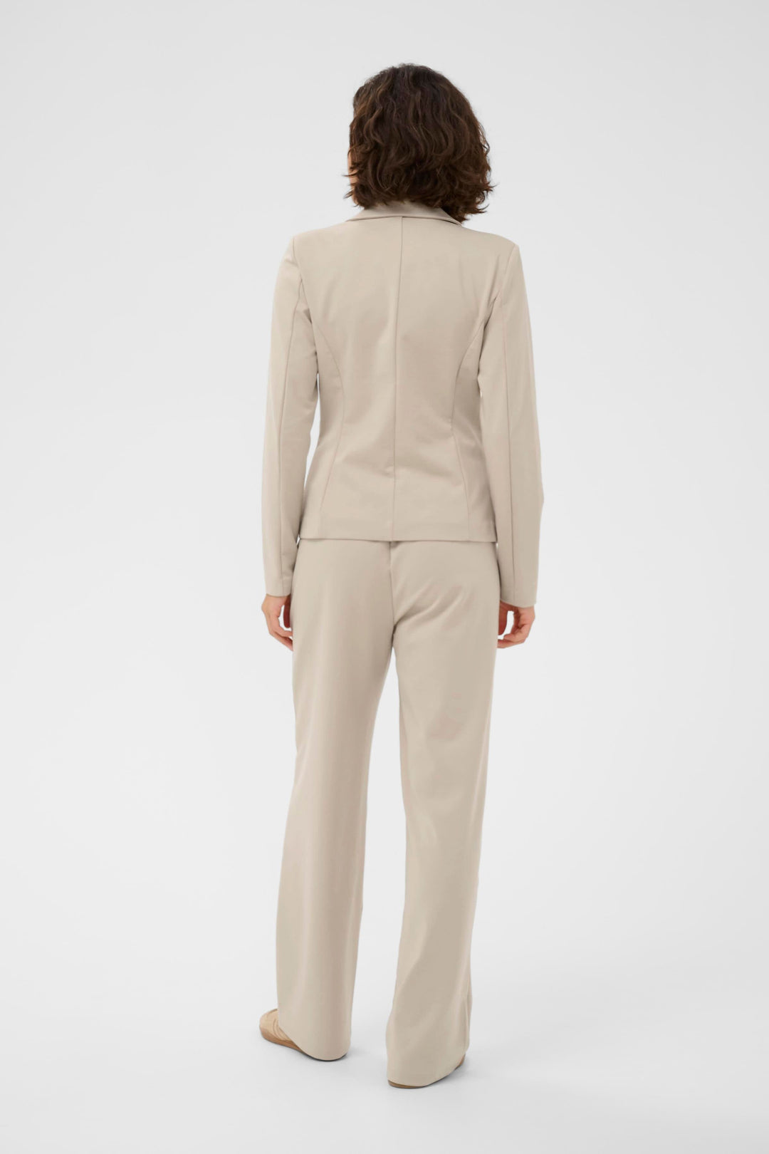 Vue arrière du Veston Jenny beige, coupe ajustée et élégante, porté avec un pantalon coordonné pour un look soigné et féminin.