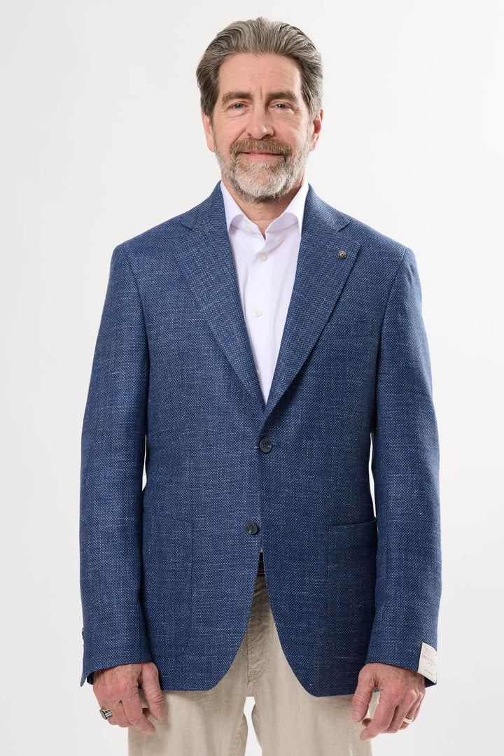 Homme portant un veston texturé bleu à la coupe moderne, idéal pour un look élégant ou décontracté.