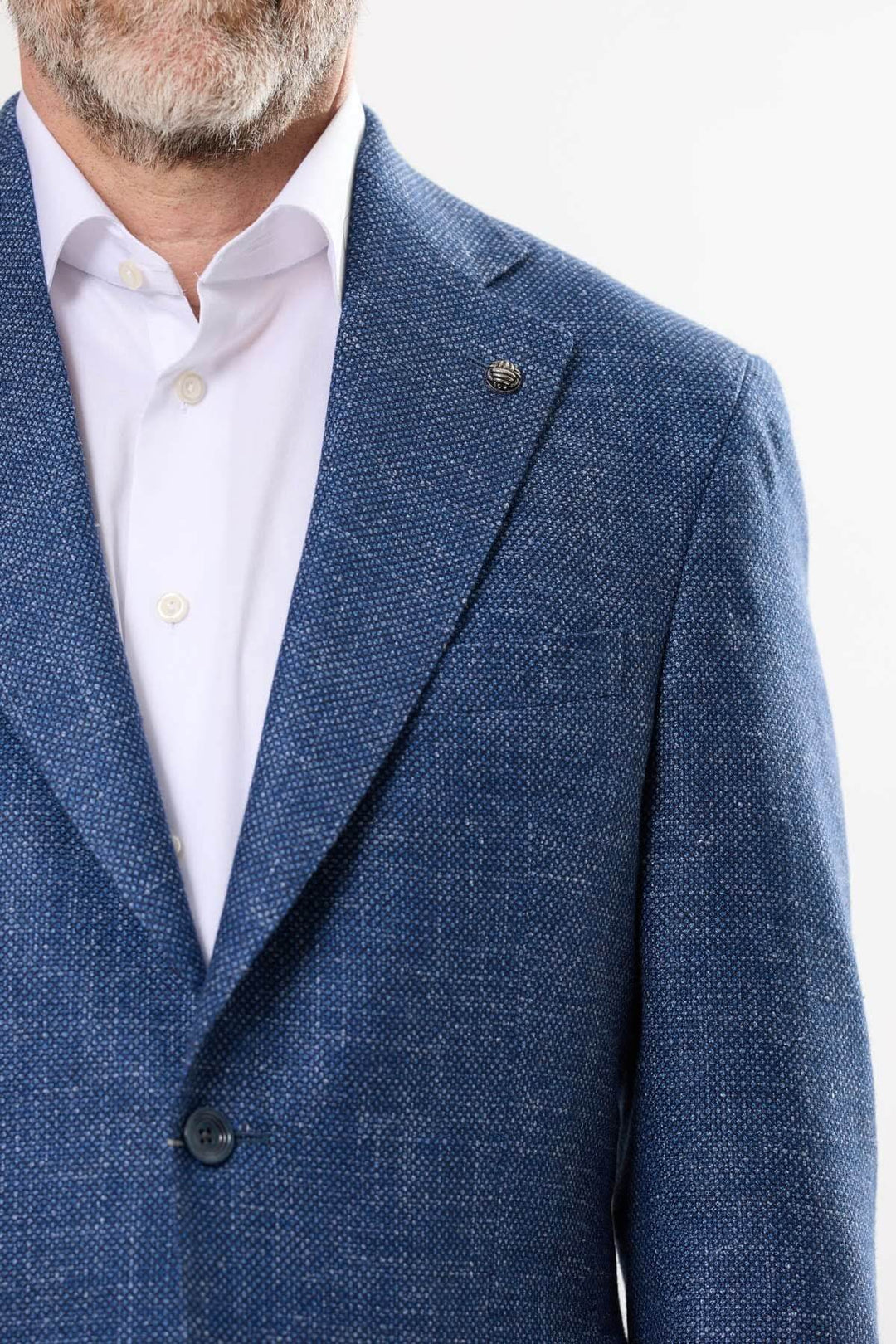 Veston Myles en tissu texturé bleu, élégant et léger, avec revers cranté et boutonnière fantaisie.