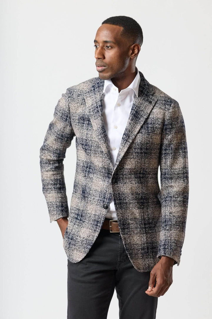 Veston à carreaux brossé deux boutons porté par un homme, sans épaulettes, coupe semi-ajustée pour un look urbain élégant.