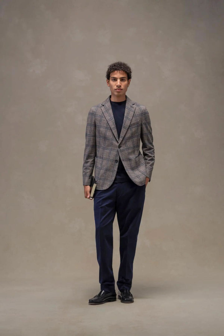 Homme portant un veston à carreaux coton extensible avec pantalon foncé, style moderne, élégant et polyvalent.