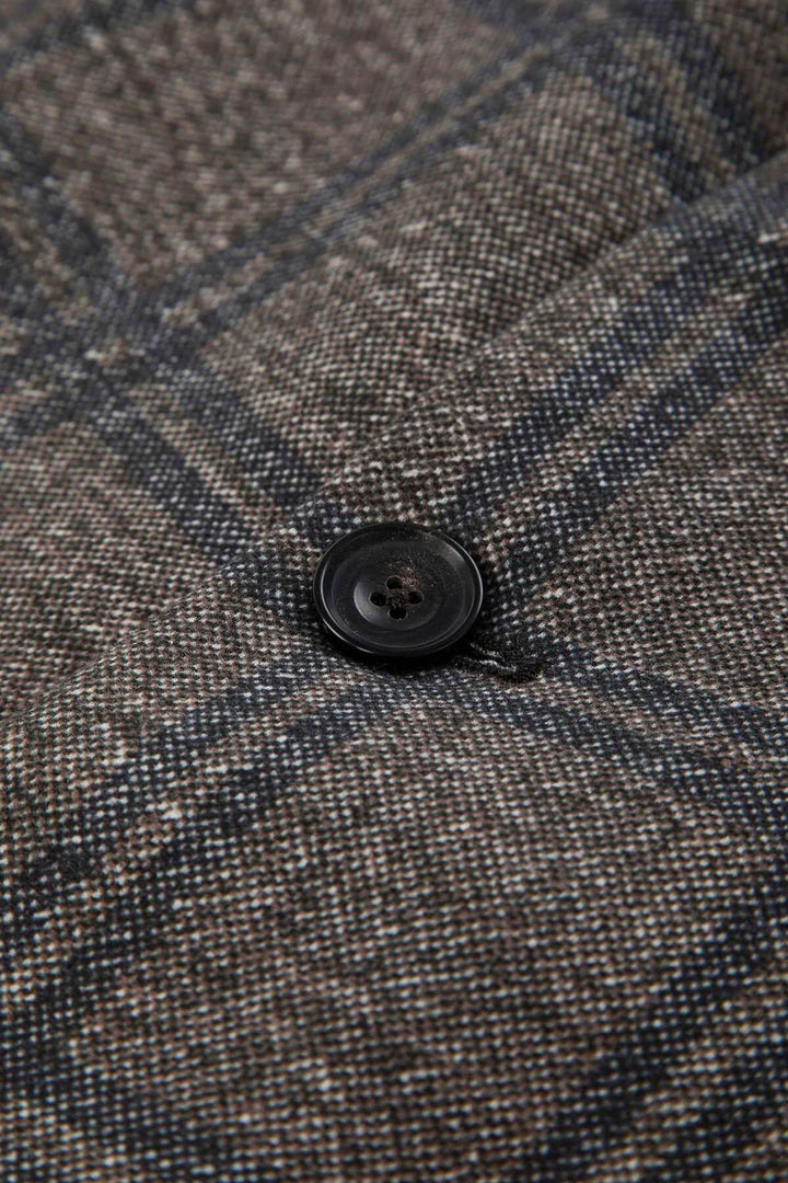 Gros plan sur un bouton du veston à carreaux coton extensible montrant le motif élégant et la texture douce.