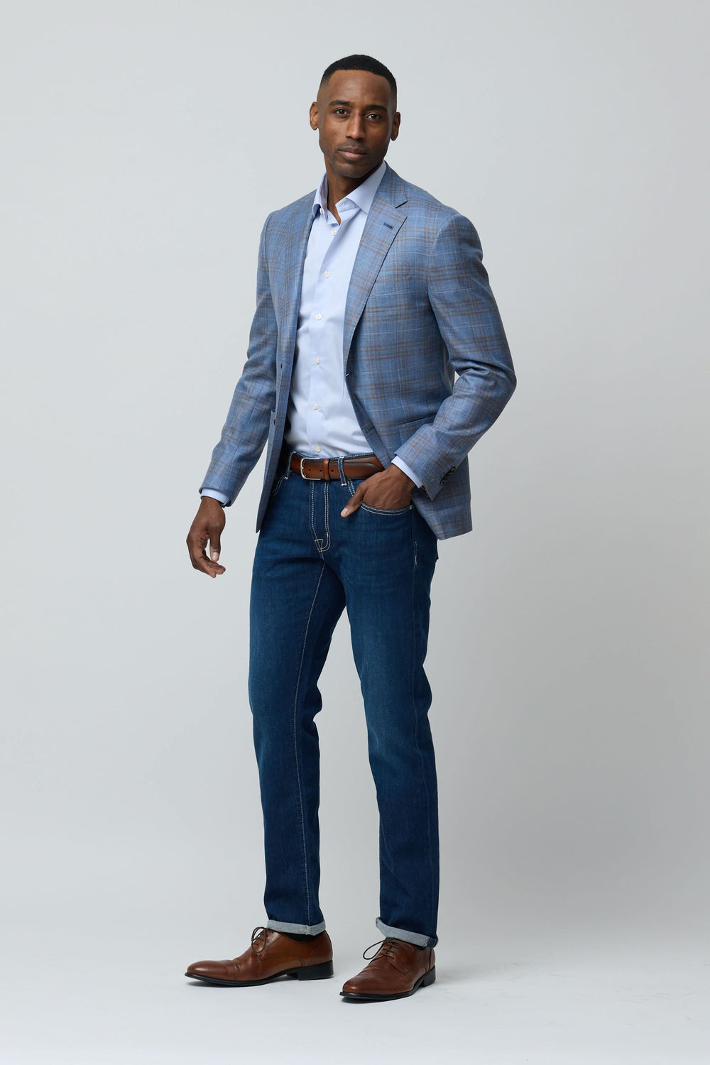 Homme portant un Veston à carreaux en laine, soie et lin avec chemise blanche et jeans pour un look chic décontracté.