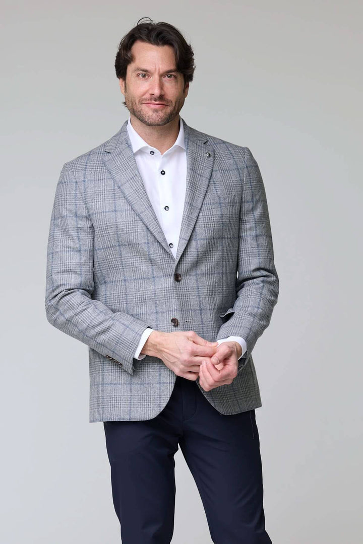 Homme portant un veston à carreaux moderne élégant pour une allure professionnelle ou occasions spéciales.