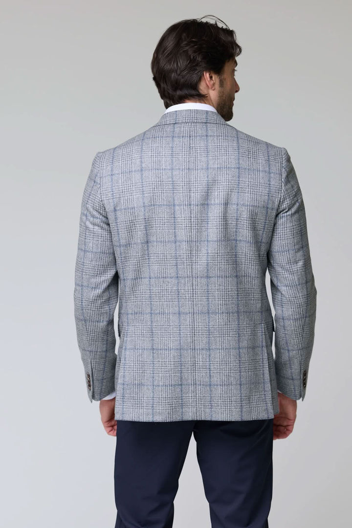 Homme portant un veston à carreaux moderne coupe ajustée avec un motif subtil, idéal pour bureau ou occasions spéciales.