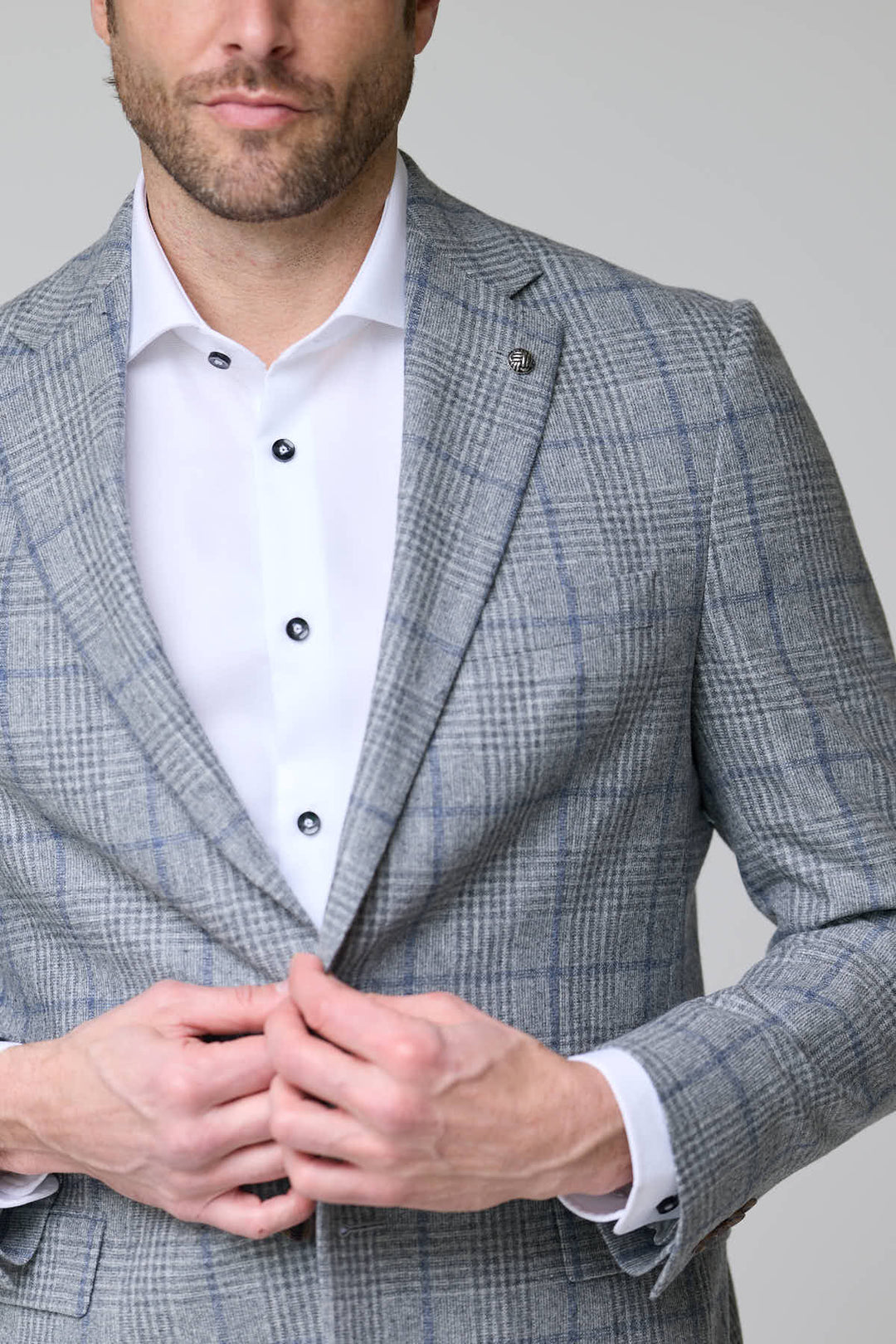 Homme portant un veston à carreaux moderne avec chemise blanche, style moderne et raffiné.