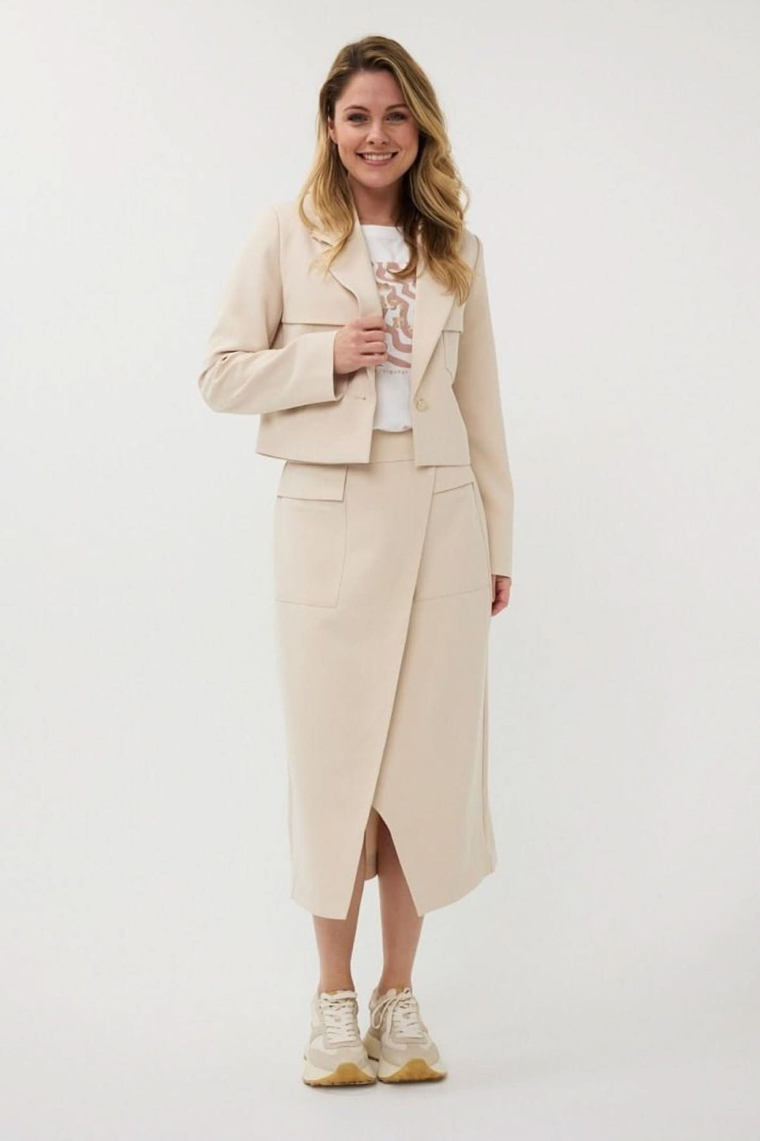 Veston court structuré avec poches surdimensionnées, porté sur t-shirt graphique pour un look moderne et féminin.