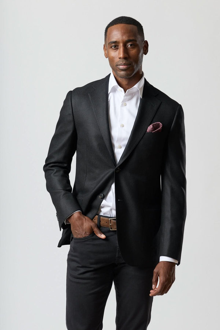 Homme portant un veston en laine et cachemire noir, élégance italienne, texture satinée, raffinement Corneliani, tenue formelle.